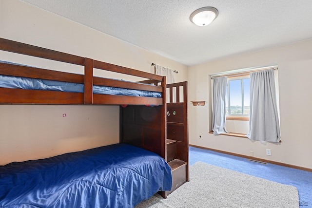 bedroom featuring carpet flooring, baseboards, and a textured ceiling