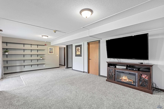 unfurnished living room with carpet floors, baseboards, and a textured ceiling