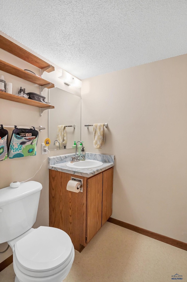 half bathroom with a textured ceiling, toilet, and vanity