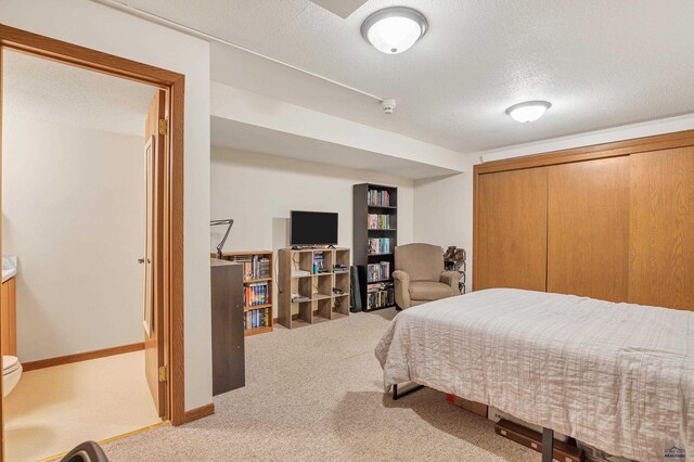 bedroom featuring a textured ceiling, carpet floors, and a closet