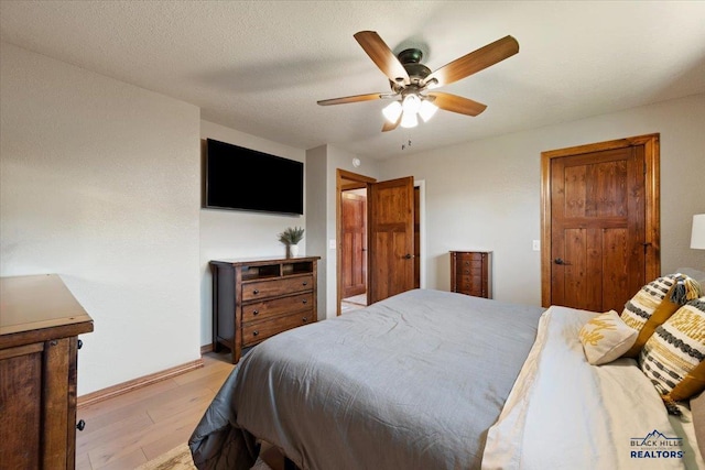 bedroom with light wood-style flooring, baseboards, and ceiling fan