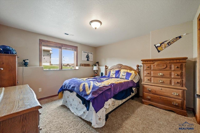 bedroom with carpet, baseboards, and a textured ceiling