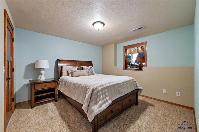bedroom with light colored carpet, baseboards, and a textured ceiling