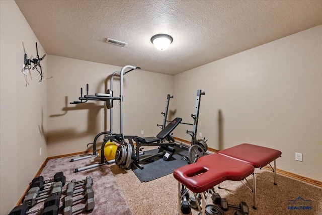 workout area with a textured ceiling, baseboards, and carpet