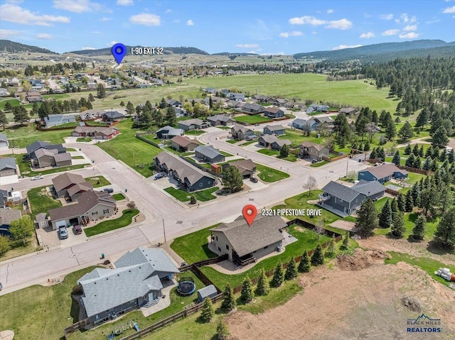 aerial overview of property's location featuring nearby suburban area and a mountainous background