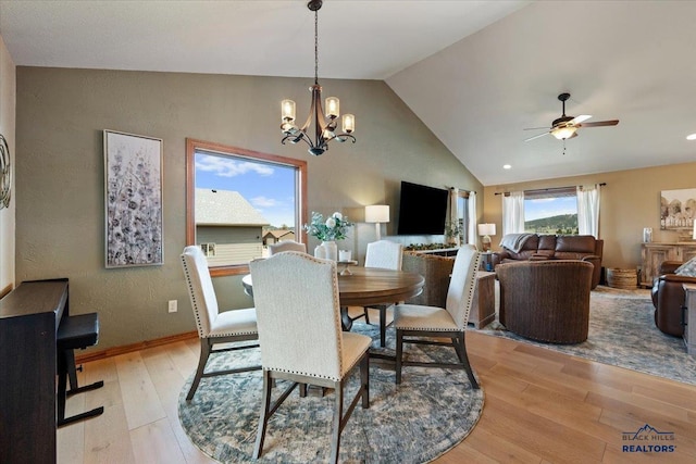 dining area with light wood-style floors, ceiling fan, a chandelier, and high vaulted ceiling