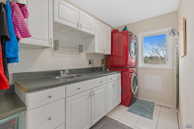 4037 Valley W Dr, Rapid City, SD 57702 - laundry area with stacked washing machine and dryer, light tile patterned floors, cabinet space, beverage cooler, and baseboards