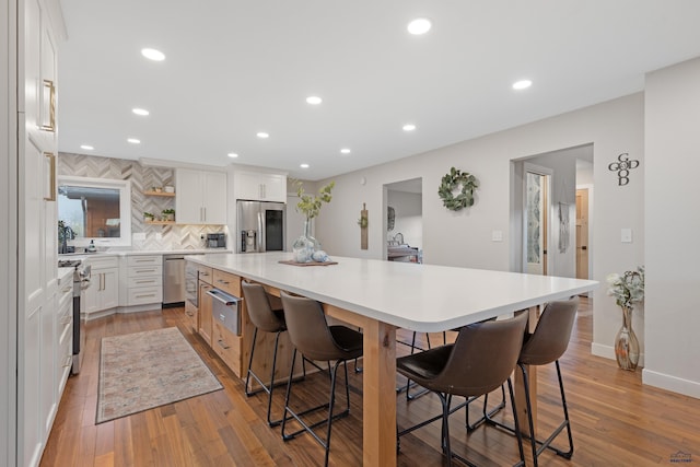 4037 Valley W Dr, Rapid City, SD 57702 - kitchen with stainless steel appliances, a large island, tasteful backsplash, a breakfast bar, and open shelves