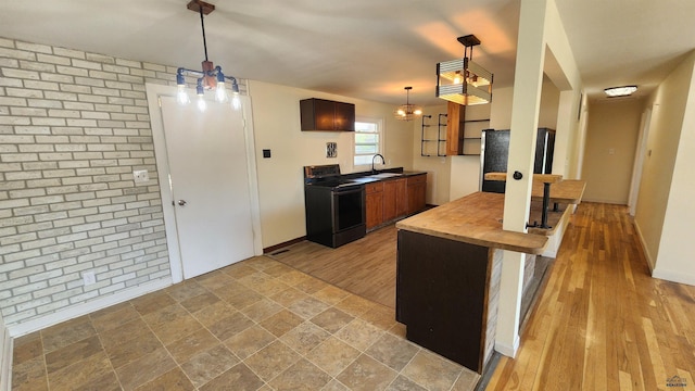 2408 Judy Ave, Rapid City, SD 57702 - kitchen with electric stove, a sink, pendant lighting, wood finished floors, and wood counters
