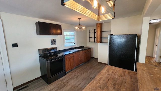 2408 Judy Ave, Rapid City, SD 57702 - kitchen with black range with electric stovetop, freestanding refrigerator, a sink, dark countertops, and wood finished floors