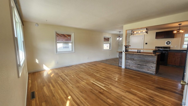 2408 Judy Ave, Rapid City, SD 57702 - unfurnished living room featuring wood-type flooring, plenty of natural light, and baseboards
