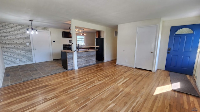 2408 Judy Ave, Rapid City, SD 57702 - unfurnished living room with wood finished floors, brick wall, and a sink