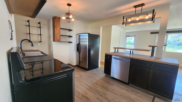 2408 Judy Ave, Rapid City, SD 57702 - kitchen with appliances with stainless steel finishes, dark cabinets, butcher block countertops, light wood finished floors, and a sink