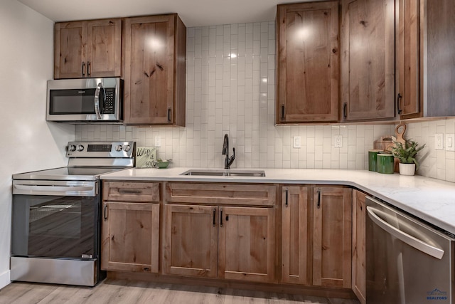 3432 Jackson Blvd, Rapid City, SD 57702 - kitchen featuring appliances with stainless steel finishes, a sink, tasteful backsplash, light countertops, and light wood-style flooring