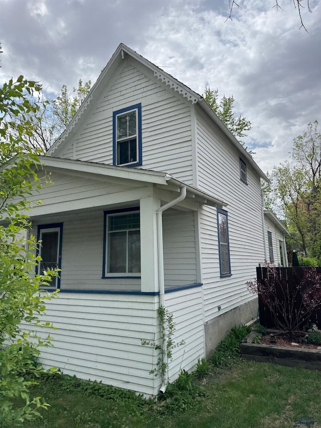 view of side of home featuring covered porch