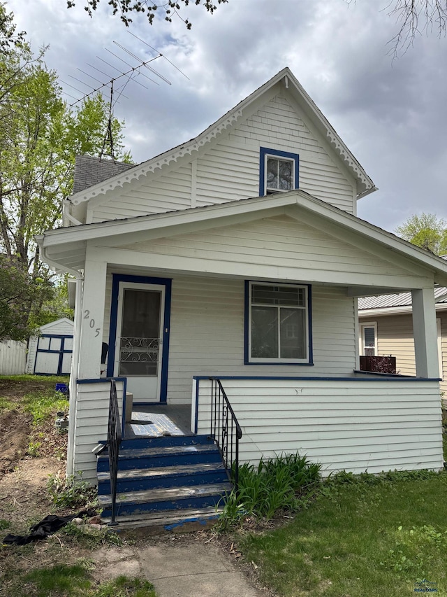 view of front of property featuring covered porch, a shed, and an outdoor structure