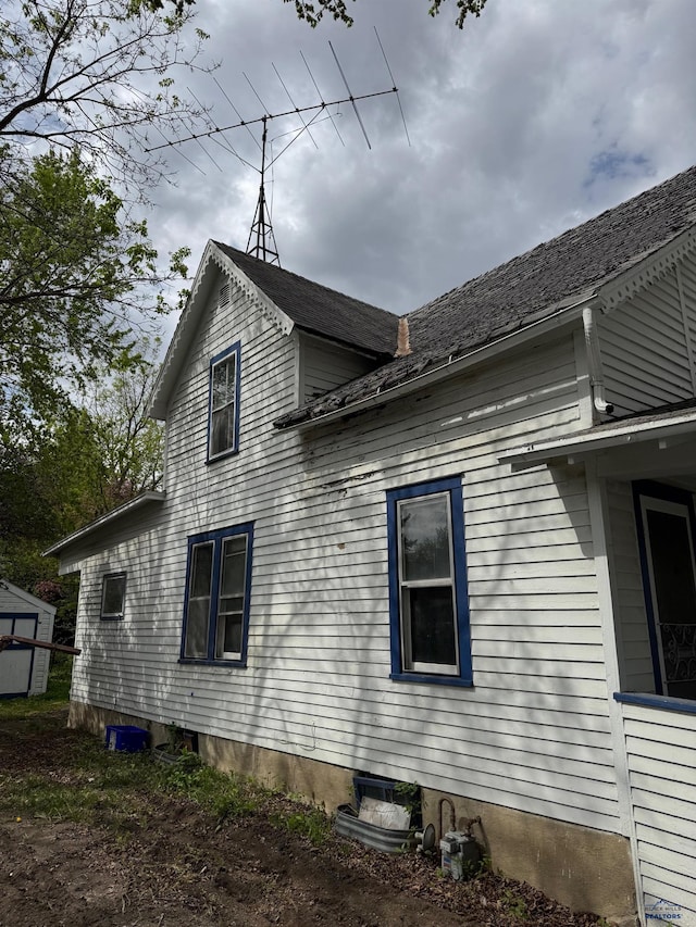 view of home's exterior featuring a storage unit and an outbuilding