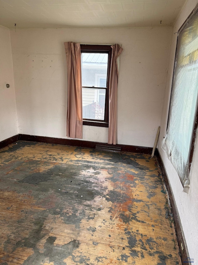 spare room with hardwood / wood-style floors and baseboards