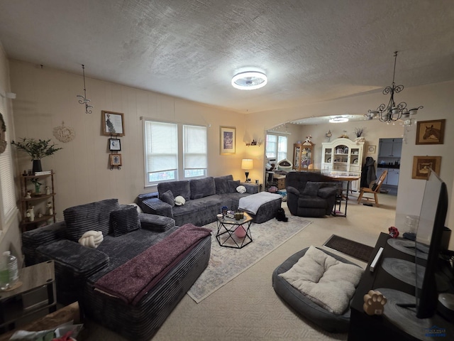 142 W Summit, Lead, SD 57754 - living room with carpet floors, a chandelier, a textured ceiling, and arched walkways