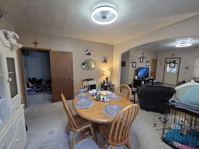 142 W Summit, Lead, SD 57754 - dining space featuring light carpet, a textured ceiling, and arched walkways