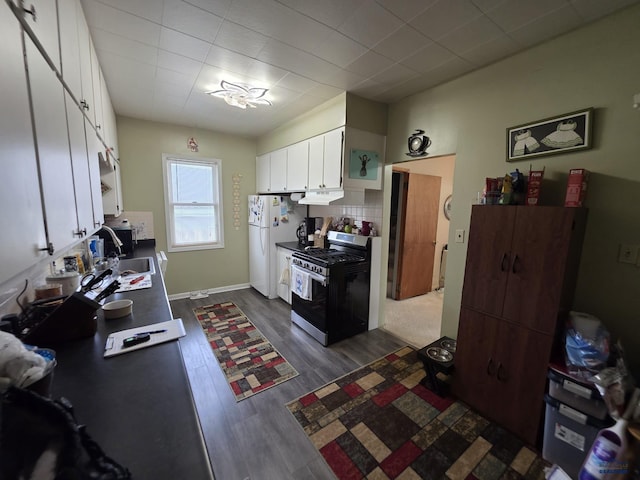 142 W Summit, Lead, SD 57754 - kitchen with gas stove, freestanding refrigerator, white cabinetry, dark wood-type flooring, and under cabinet range hood