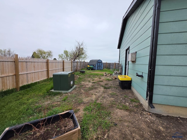 fenced backyard featuring a storage shed, an outdoor structure, and a vegetable garden