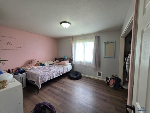 bedroom featuring wood finished floors and baseboards