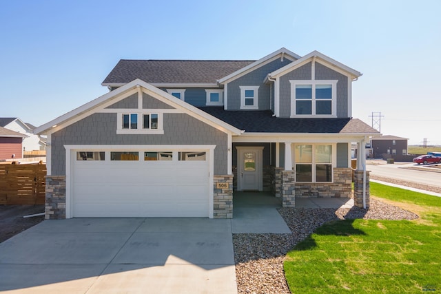 506 Solomon Ct, Rapid City, SD 57703 - craftsman-style house with stone siding, covered porch, roof with shingles, and driveway