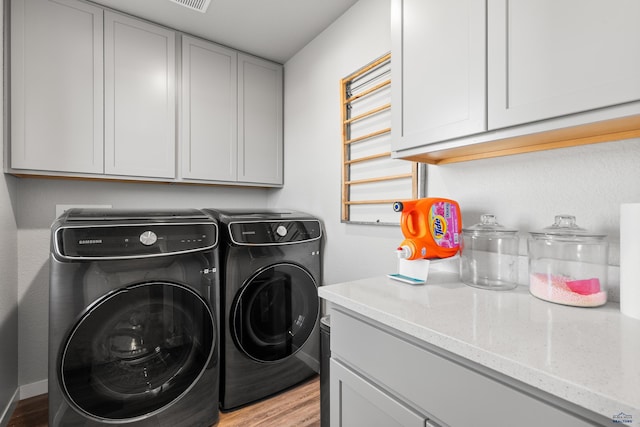 506 Solomon Ct, Rapid City, SD 57703 - washroom with separate washer and dryer, cabinet space, and light wood-style flooring