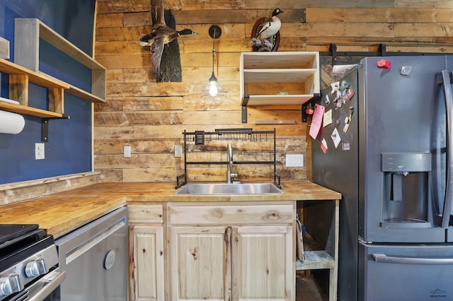 24427 Thovson Rd, Keystone, SD 57751 - kitchen with appliances with stainless steel finishes, a sink, butcher block countertops, wood walls, and open shelves