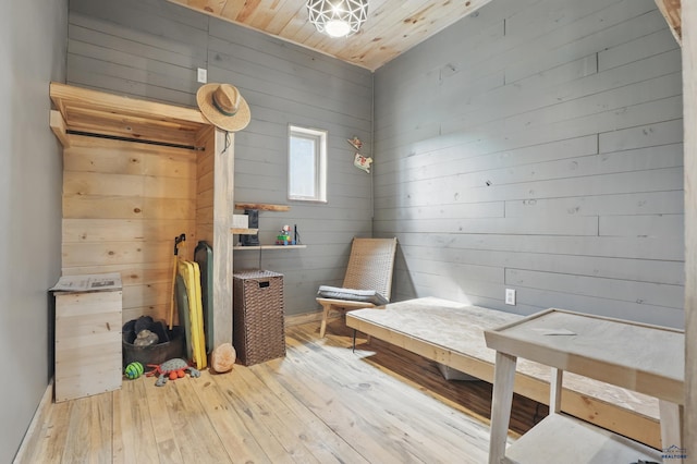 24427 Thovson Rd, Keystone, SD 57751 - sitting room featuring hardwood / wood-style floors, wooden walls, wooden ceiling, and baseboards