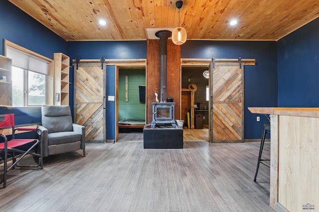 24427 Thovson Rd, Keystone, SD 57751 - living room featuring a barn door, wood ceiling, recessed lighting, a wood stove, and wood finished floors