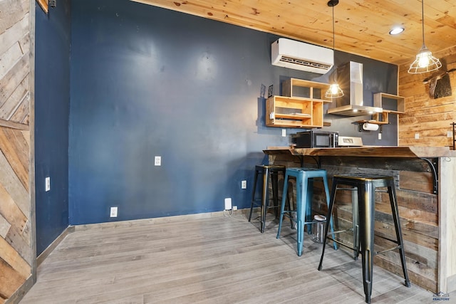 24427 Thovson Rd, Keystone, SD 57751 - kitchen with an AC wall unit, wooden ceiling, wood finished floors, wood walls, and wall chimney exhaust hood