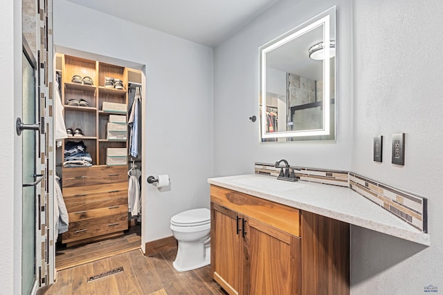 819 Sly St, Sturgis, SD 57785 - bathroom featuring wood finished floors, toilet, and vanity