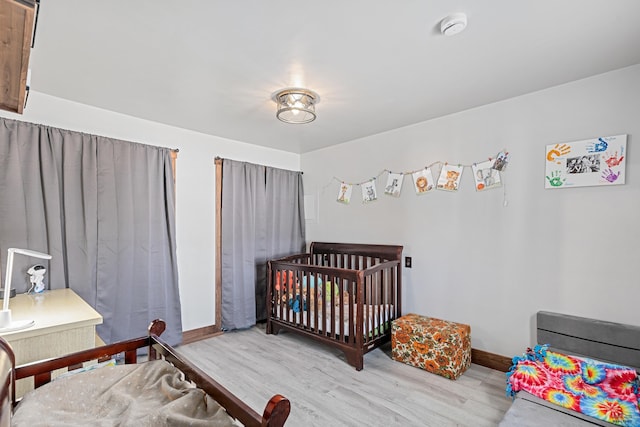 819 Sly St, Sturgis, SD 57785 - bedroom with wood finished floors, baseboards, and a nursery area