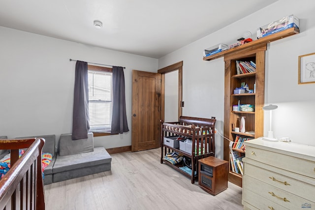 819 Sly St, Sturgis, SD 57785 - bedroom with light wood-style flooring, a wood stove, and baseboards