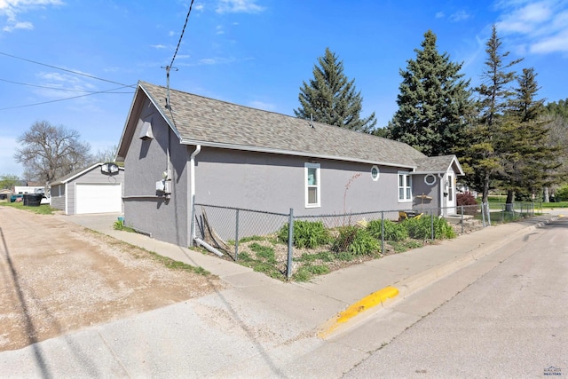819 Sly St, Sturgis, SD 57785 - view of side of home with stucco siding, a detached garage, dirt driveway, and an outdoor structure