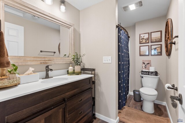 202 S B Ave, New Underwood, SD 57761 - full bath featuring toilet, vanity, wood finished floors, baseboards, and a shower with shower curtain