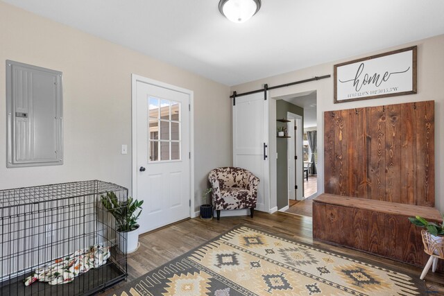 202 S B Ave, New Underwood, SD 57761 - entryway with electric panel, wood finished floors, a barn door, and baseboards
