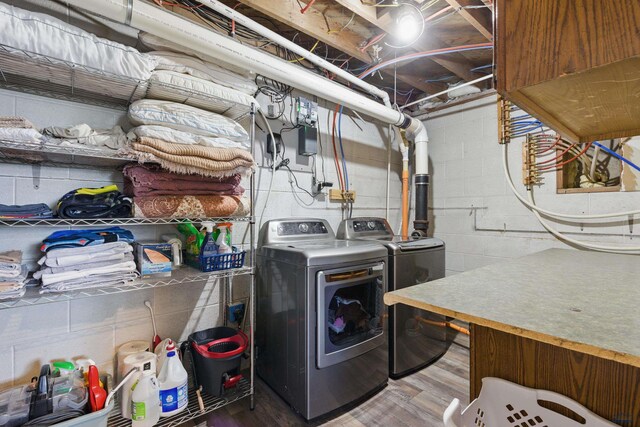 202 S B Ave, New Underwood, SD 57761 - laundry room with separate washer and dryer, wood finished floors, and concrete block wall