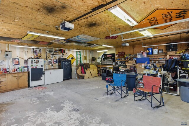 202 S B Ave, New Underwood, SD 57761 - garage with a workshop area, a garage door opener, and freestanding refrigerator
