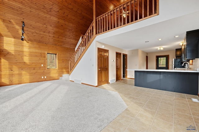 12087 Kaubisch Ranch Rd, Hill City, SD 57745 - unfurnished living room featuring wood walls, wooden ceiling, high vaulted ceiling, stairs, and light tile patterned floors