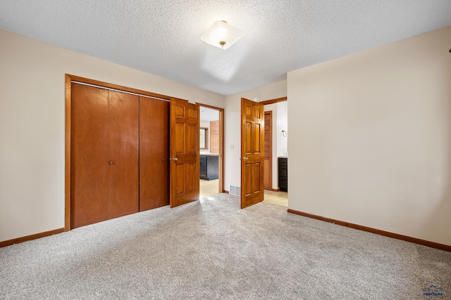 12087 Kaubisch Ranch Rd, Hill City, SD 57745 - unfurnished bedroom with light carpet, a closet, a textured ceiling, and baseboards