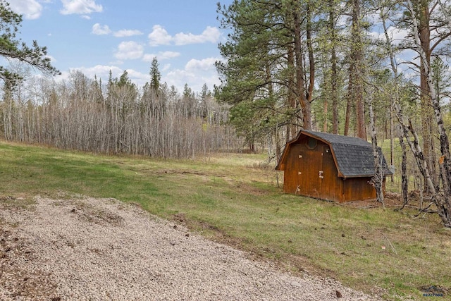 12087 Kaubisch Ranch Rd, Hill City, SD 57745 - view of grassy yard featuring a shed, an outdoor structure, and a forest view