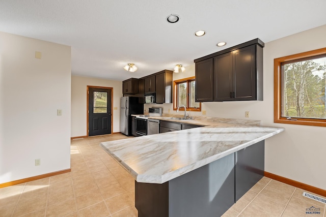 12087 Kaubisch Ranch Rd, Hill City, SD 57745 - kitchen with electric stove, a sink, baseboards, dark brown cabinetry, and a peninsula