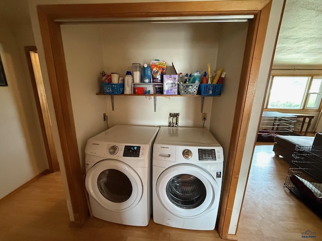 laundry room with separate washer and dryer and light wood-style floors
