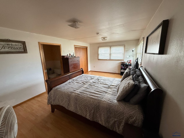bedroom featuring wood finished floors and baseboards