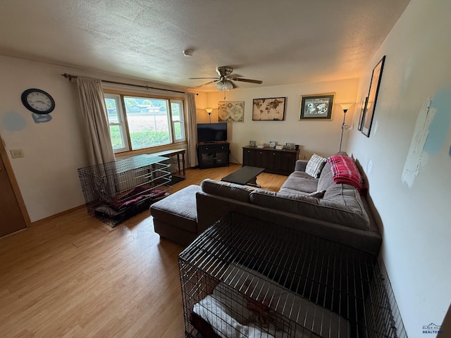 living room with light wood-style flooring and a ceiling fan