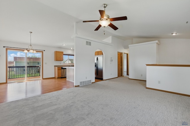573 Plover Dr, Box Elder, SD 57719 - unfurnished living room with ceiling fan, arched walkways, a chandelier, vaulted ceiling, and baseboards