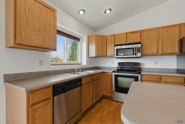 573 Plover Dr, Box Elder, SD 57719 - kitchen featuring appliances with stainless steel finishes, a sink, vaulted ceiling, light wood-type flooring, and light countertops